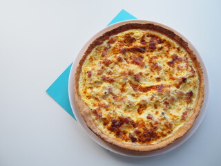 Homemade traditional french Quiche Lorraine, real recipe, white and blue background, space for text