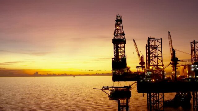 Jack up drilling rig and production platform in the middle of the ocean at sunrise time
