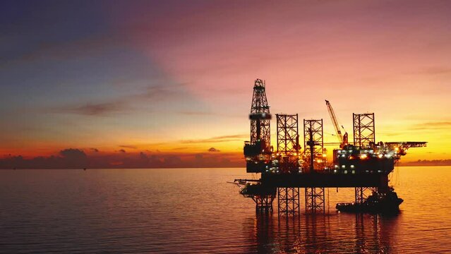Jack up drilling rig and production platform in the middle of the ocean at sunrise time
