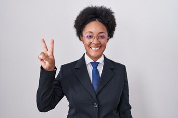 Beautiful african woman with curly hair wearing business jacket and glasses showing and pointing up with fingers number two while smiling confident and happy.