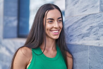 Young beautiful hispanic woman smiling confident looking to the side at street