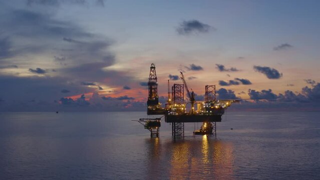 Jack up drilling rig and production platform in the middle of the ocean at sunrise time
