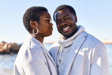 Man and woman couple hugging each other standing at seaside