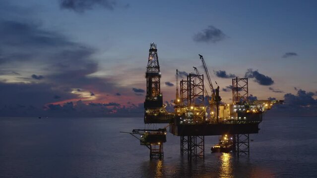 Jack up drilling rig and production platform in the middle of the ocean at sunrise time
