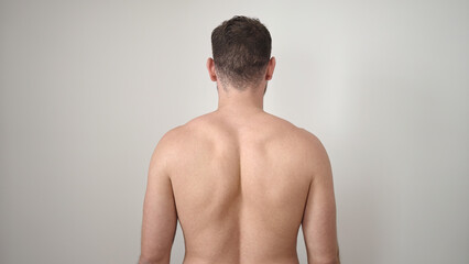 Young caucasian man standing backwards shirtless over isolated white background