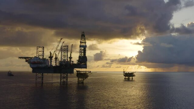 Jack up drilling rig and production platform in the middle of the ocean at sunrise time
