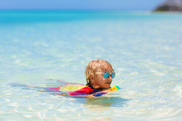 Kids surf on tropical beach. Vacation with child.