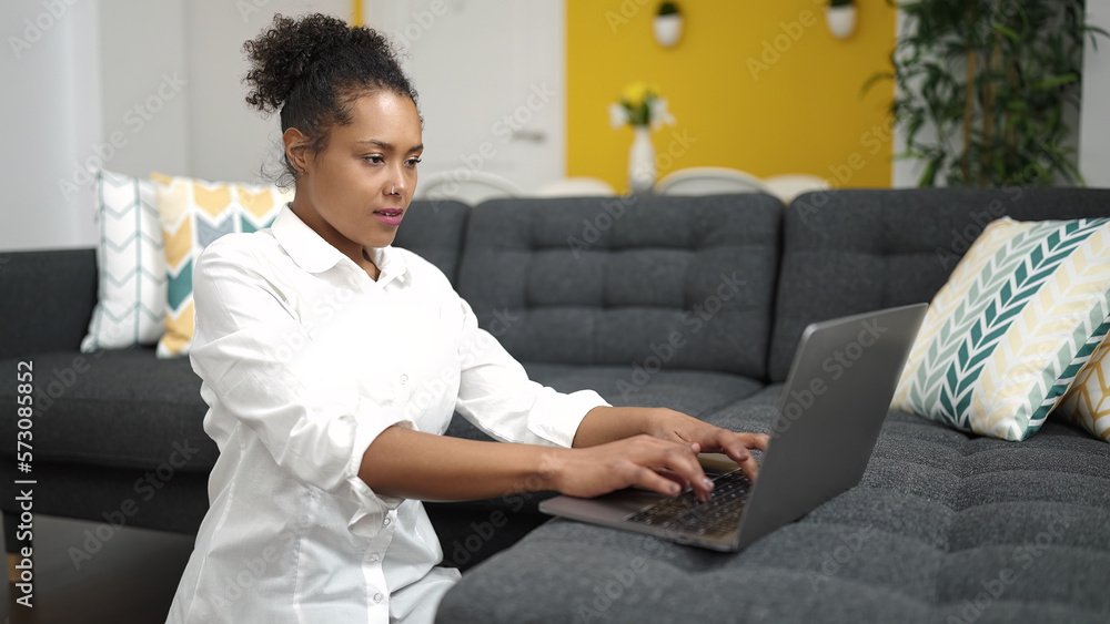 Sticker African american woman using laptop sitting on floor at home