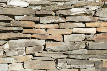 field stone layered retaining wall in the sun