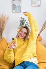 Happy woman using smartphone in living room