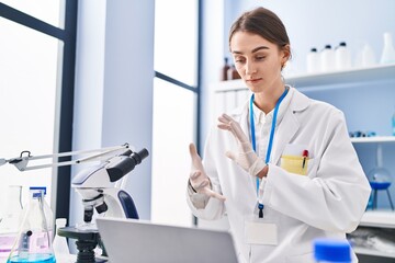 Young caucasian woman scientist having video call at laboratory