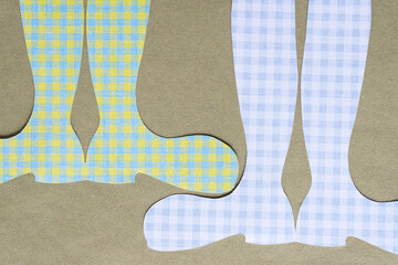 two pairs of paper boot shapes on rough green paper