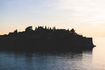 Naklejka premium View of Sveti Stefan, a town in Budva Municipality, Budva Riviera, on the Adriatic sea coast, Saint Stephen island, Montenegro, sunny day with a blue sky, travel to Montenegro