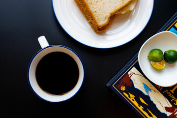 cup of coffee and bread, breakfast on a black background