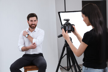Obraz premium Professional photographer working with handsome model in modern photo studio