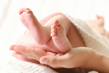 Mother and her newborn baby on bed, closeup view