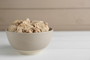 Bowl of tasty cod liver on white wooden table. Space for text