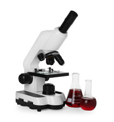 Laboratory glassware with red liquid and microscope isolated on white