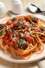 Delicious pasta with meatballs and tomato sauce served on wooden table, closeup