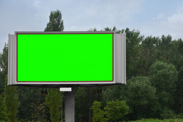 Chroma key compositing. Big empty billboard with green screen outdoors. Mockup for design