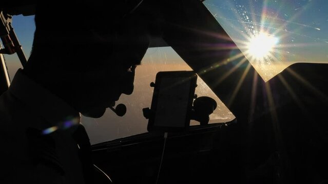 Silhouette of airline pilot captain in uniform at cruise, flying in sunset