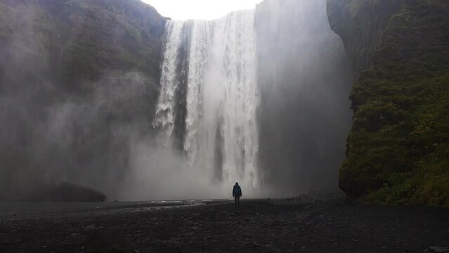 Man Standing Near Skogafoss Waterfall