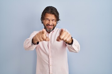 Handsome middle age man wearing elegant shirt background pointing to you and the camera with fingers, smiling positive and cheerful