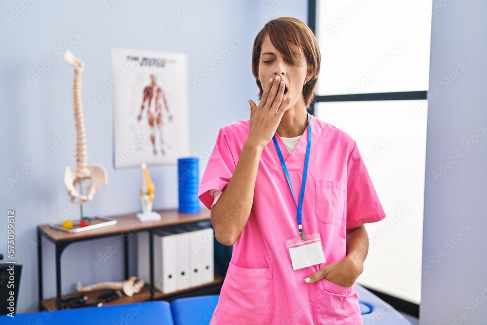 Sticker Brunette woman working at rehabilitation clinic bored yawning tired covering mouth with hand. restless and sleepiness.