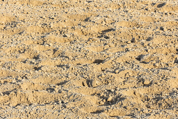 Clumpy sand on a horse racetrack when it is partially frozen.