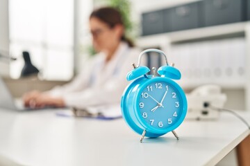 Young hispanic woman wearing doctor uniform working at clinic