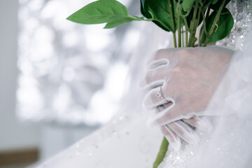 The bride holds flowers in her hands and wears a ring.