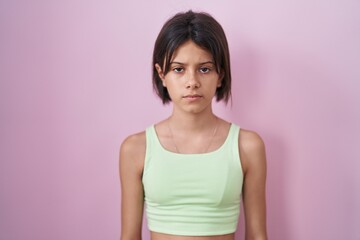 Young girl standing over pink background skeptic and nervous, frowning upset because of problem. negative person.