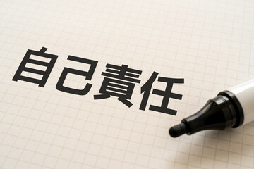 自己責任と書かれたノートとマーカー