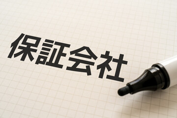 保証会社と書かれたノートとマーカー