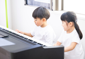 一緒にピアノを弾く子供たち