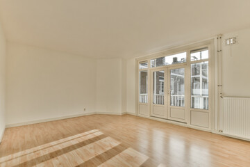 an empty living room with wood flooring and large sliding doors leading out to the balcony area in...