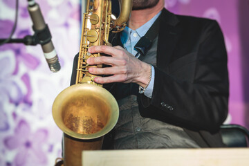 Concert view of saxophonist, a saxophone sax player with vocalist and musical band during jazz...