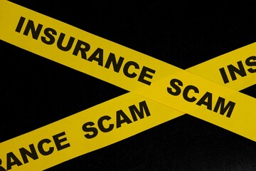 Insurance scam and fraud alert, caution and warning concept. Yellow barricade tape with word in...
