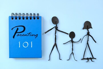 Learn parenting guide 101 concept. Word written on blue notepad with family stick figures.