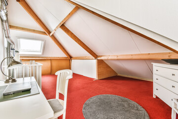 Fototapeta na wymiar an attic room with red carpet and white furniture in the corner, which is also used as a study area