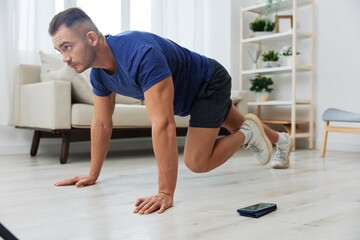 Man sportsman training at home, stretching exercises for arm, leg and back muscles, strong body and correct posture, the concept of health and beauty