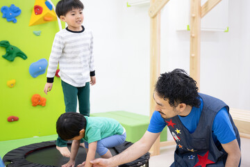  子どもと一緒に遊ぶ男性保育士のイメージ