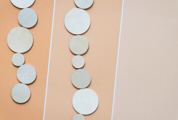 wooden circle cutouts on striped orange pastel paper pad sheet with paint chip element - macro lens, particular focus