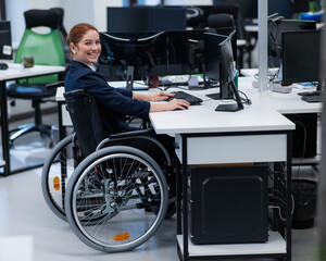 Fototapeta na wymiar Caucasian smiling woman in wheelchair at work desk. 