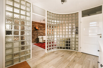 a living room with wood flooring and glass partitions on the wall to make it look like a mirror