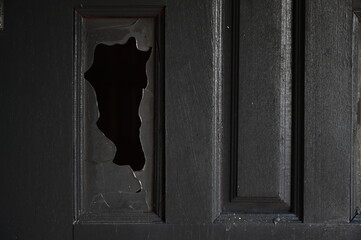 burn dirty black wood door with broken glass texture background