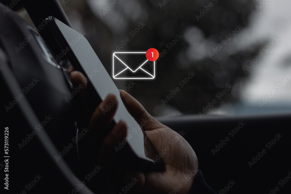 Poster close-up of driver's hand use smartphone in site car with 1 new email notification alert icon pop up