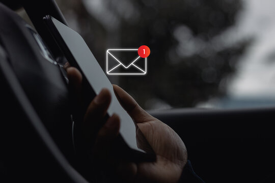 Close-up of Driver's hand use smartphone in site car with 1 new email notification alert icon pop up. Online communication business technology concept. Contact us by newsletter email, Email marketing. - Powered by Adobe