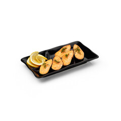 Baked mussels on a black plate with sliced lemon on a white background isolated