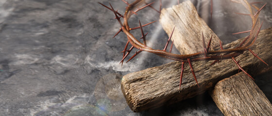 Crown of thorns and wooden cross on grunge background with space for text, closeup